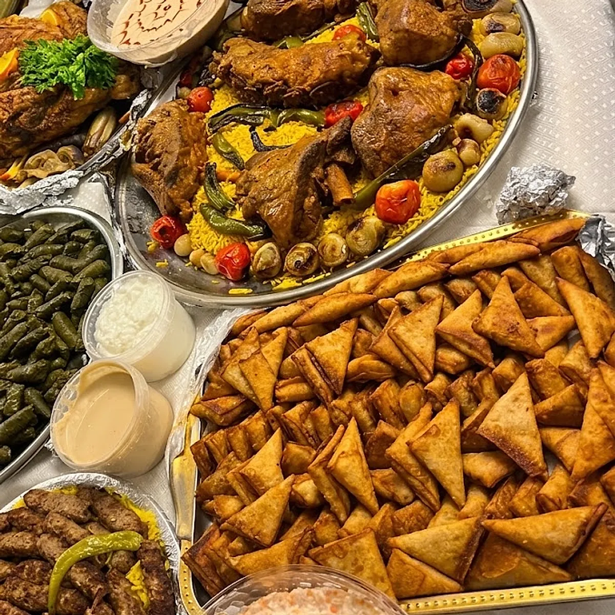 سفرة عرض العزومات: صينية فراخ على رز أصفر وصينية سمبوسة كبيرة ومحاشي وسلطات